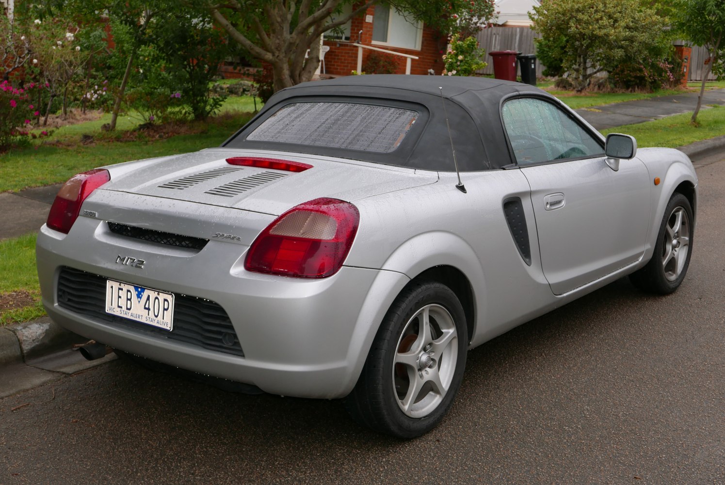 Rear view of a convertible sports car with soft top and distinctive taillights