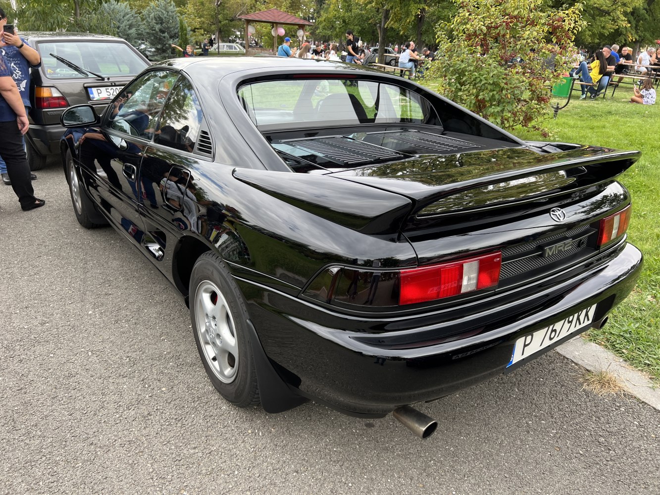Rear and side view of black sports coupe with rear spoiler and distinctive tail lights