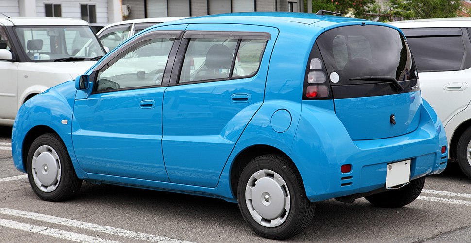 Compact blue hatchback with rounded body panels and small rear lights