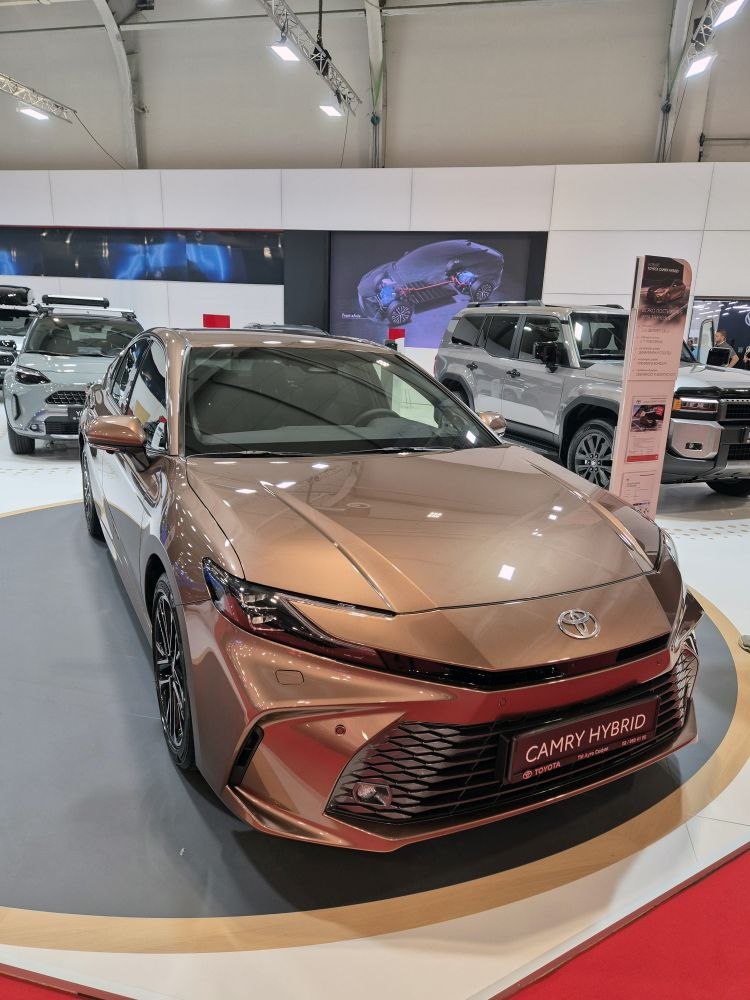 Front view of sleek modern hybrid sedan with sharp headlights and large grille