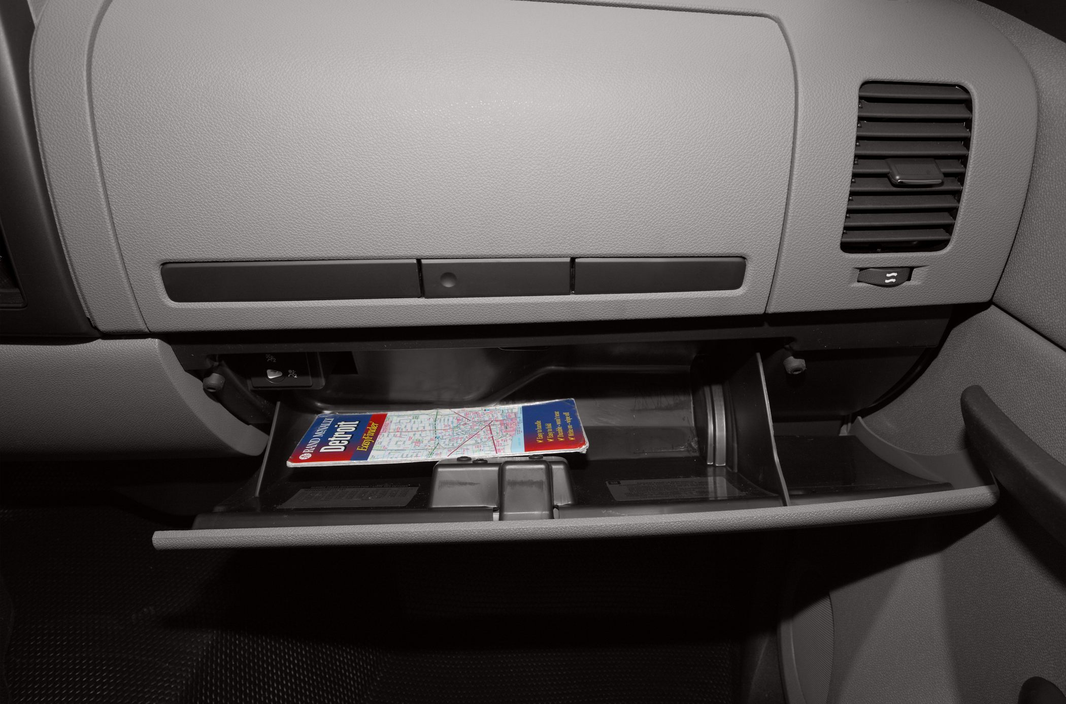 Open glove compartment with map inside in vehicle interior