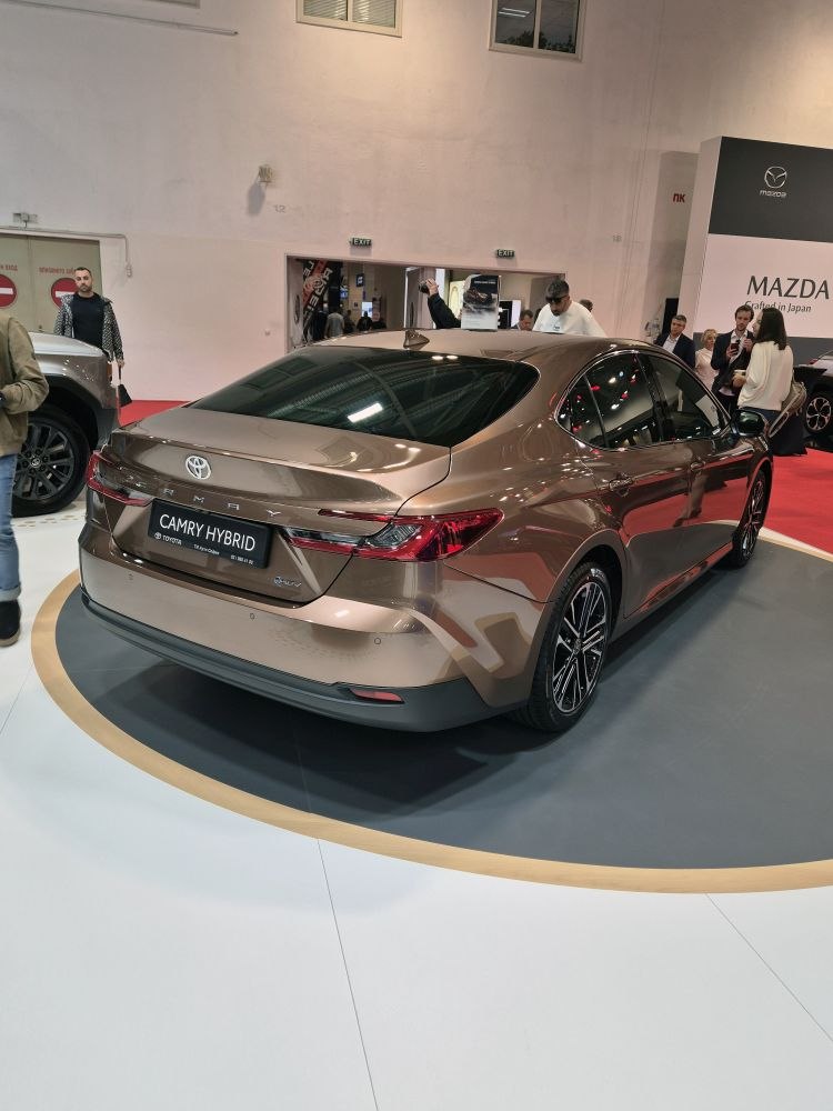 Rear view of a modern hybrid sedan with distinctive tail lights and aerodynamic design.