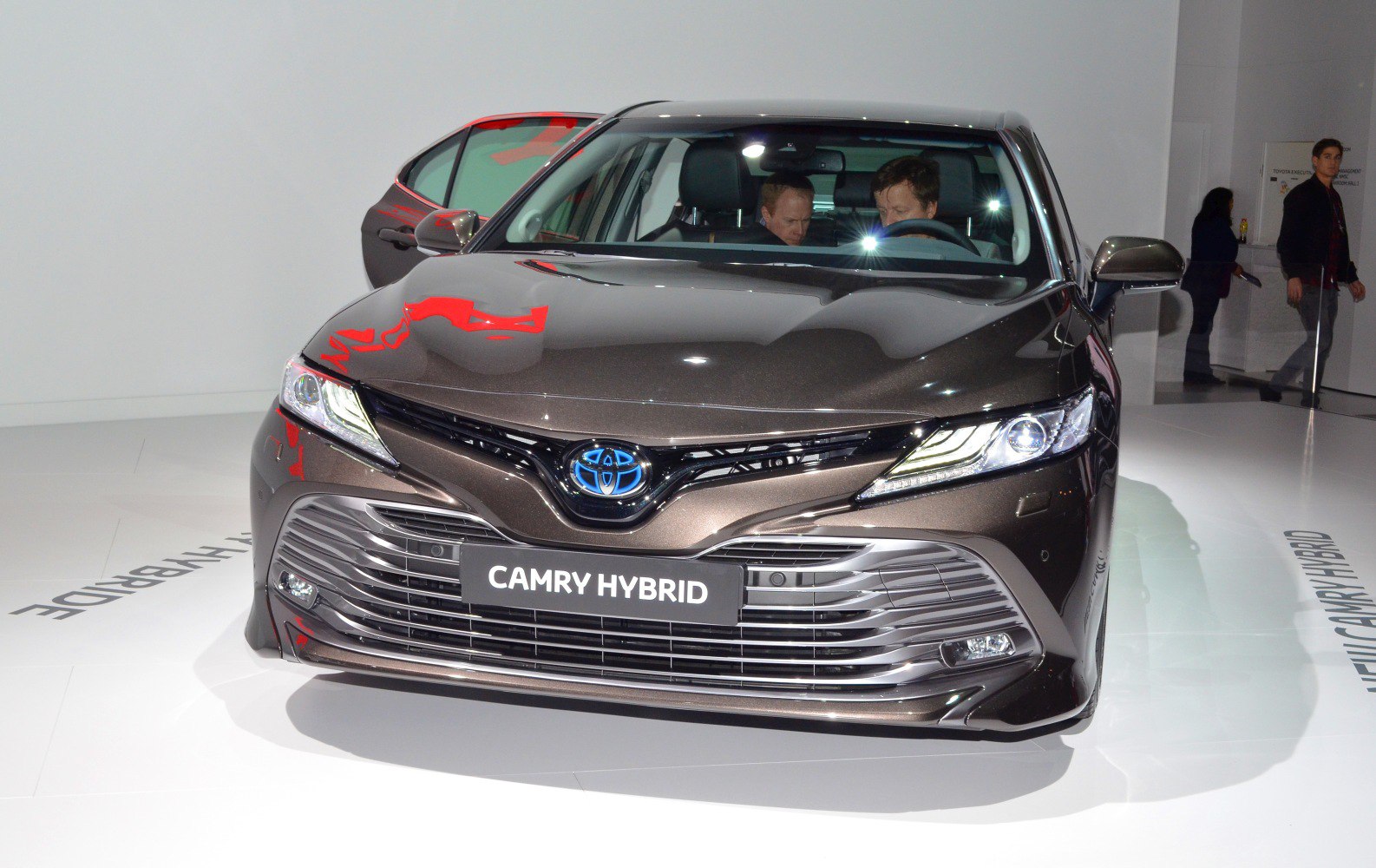 Front view of modern hybrid sedan with LED headlights and large grille