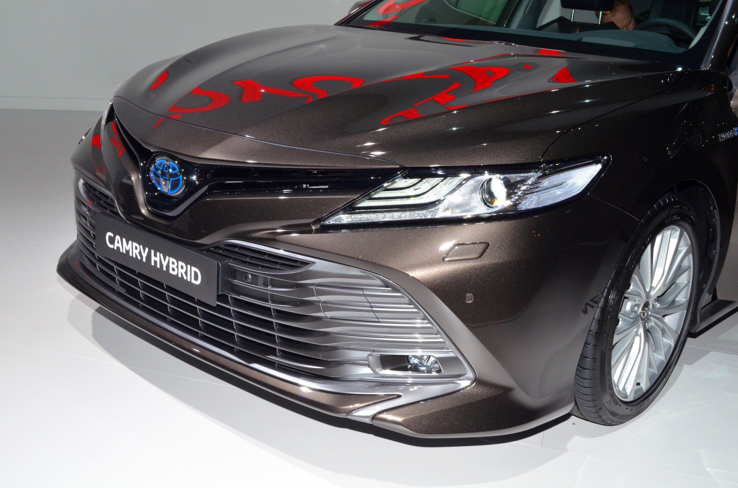 Close-up of hybrid sedan front end with LED headlights and wide grille