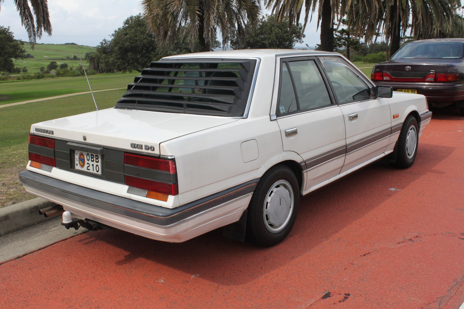 Rear window louvers and rectangular taillights on boxy 1980s sedan