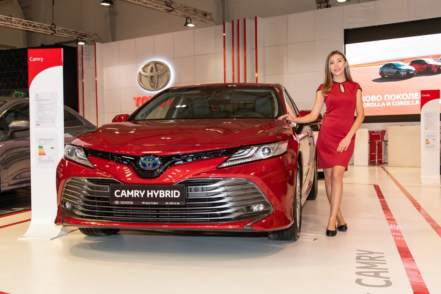 Front view of red hybrid sedan with LED headlights and sleek grille.