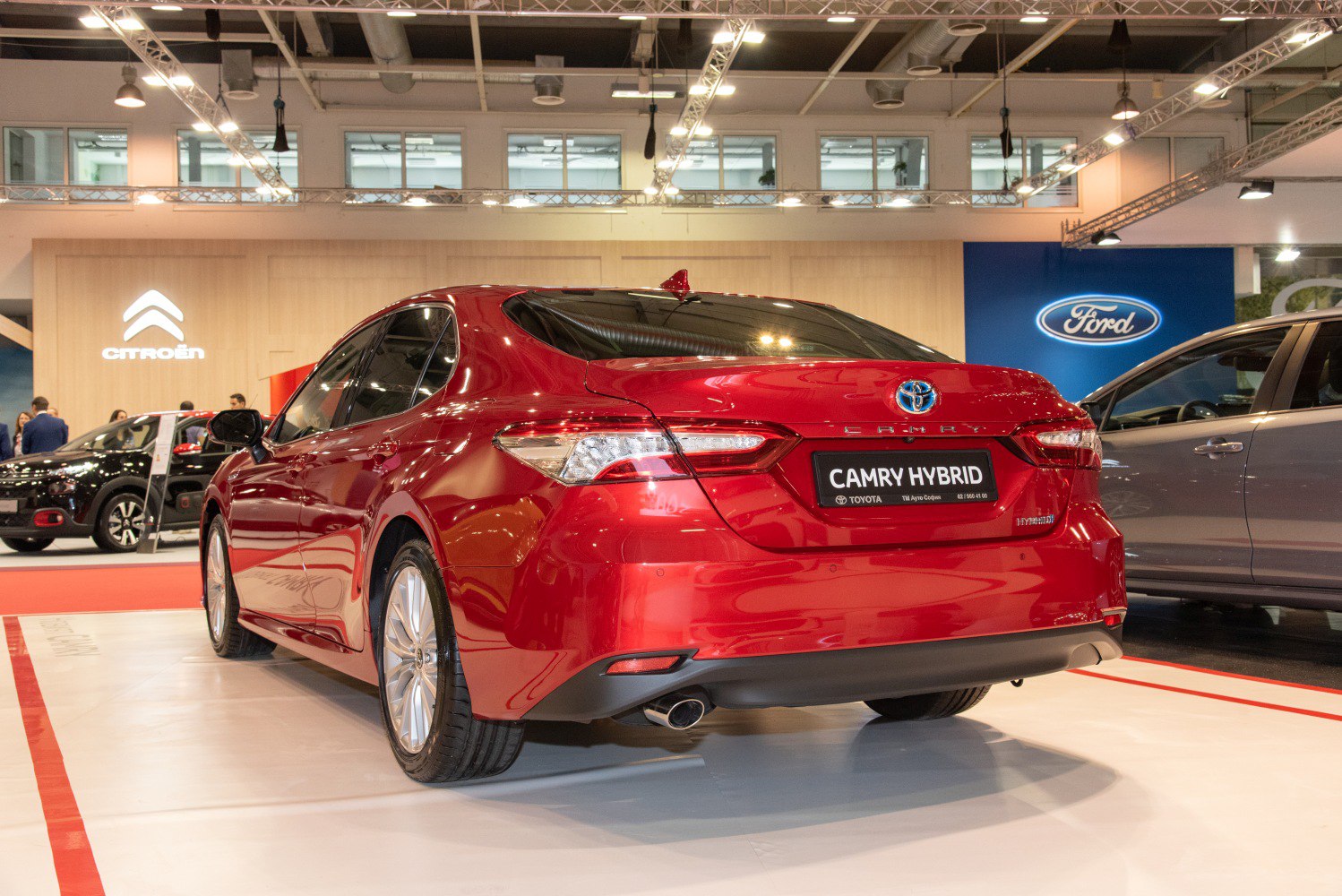 Rear view of hybrid sedan with sleek tail lights and visible exhaust pipe.