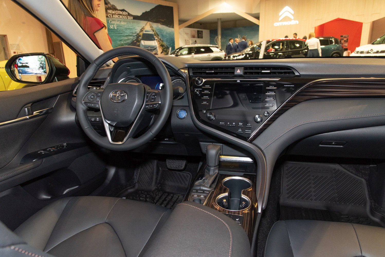Car interior dashboard with steering wheel, infotainment screen, and gear shift