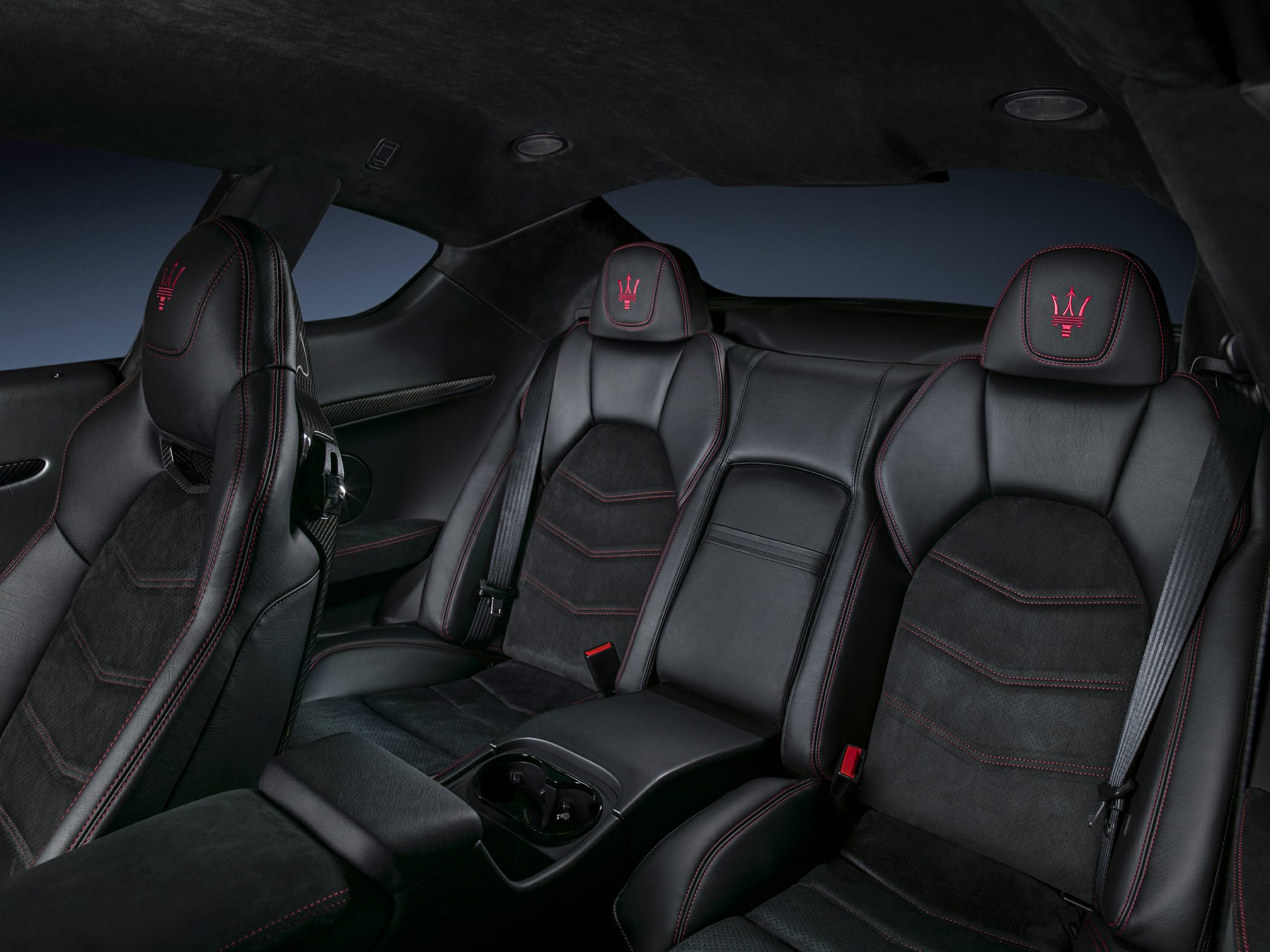 Black leather car seats with red stitching and embroidered headrests