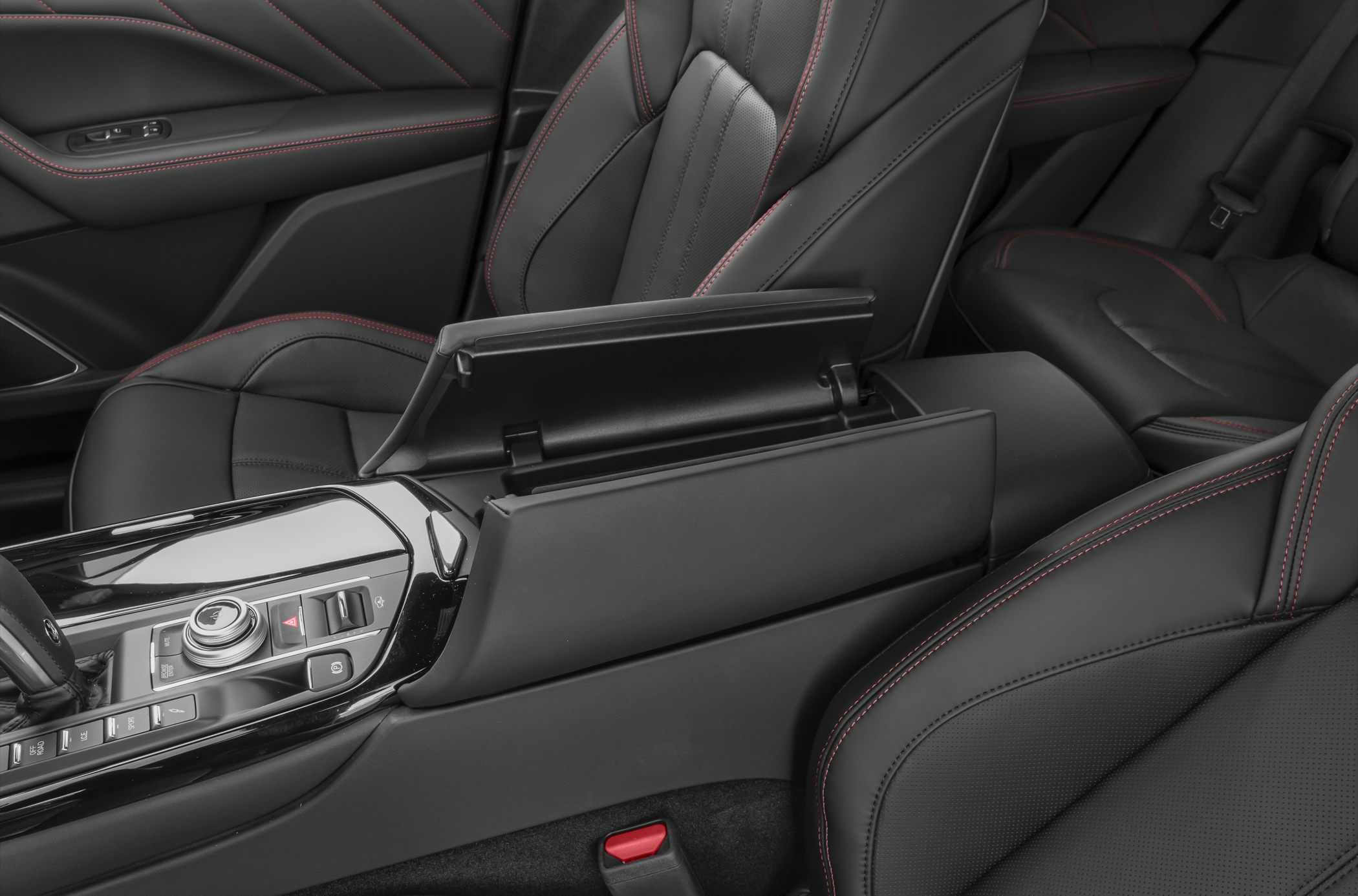 Center console with armrest storage and black leather seats with red stitching