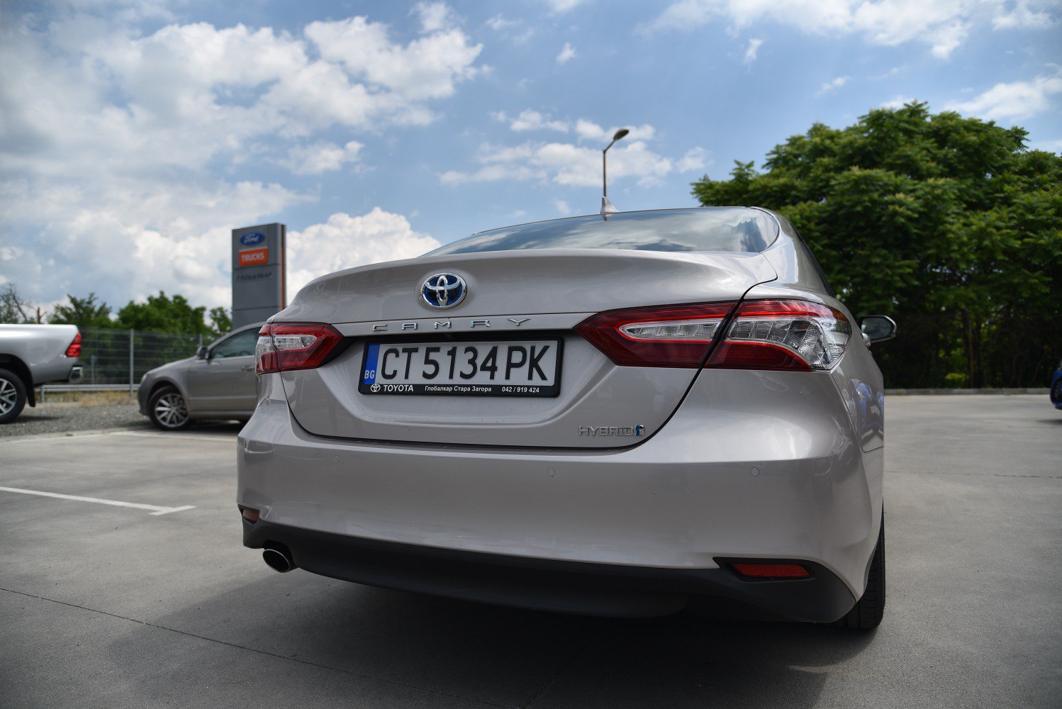 Rear view of a sedan with hybrid badge and distinctive tail lights