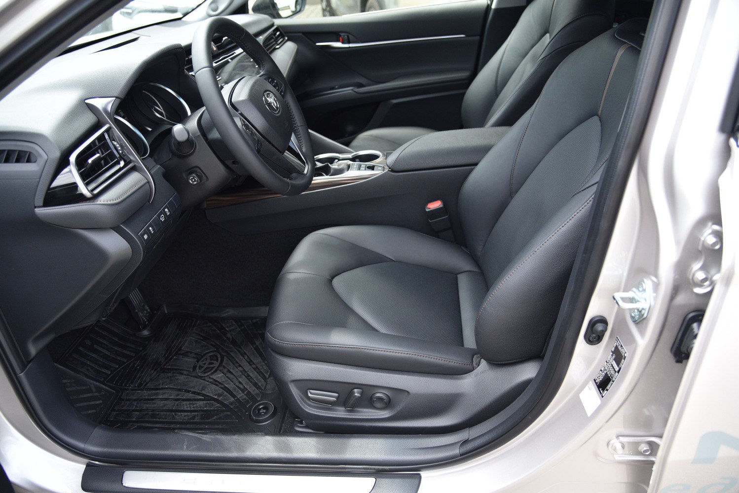 Black leather driver seat and modern dashboard with steering wheel.