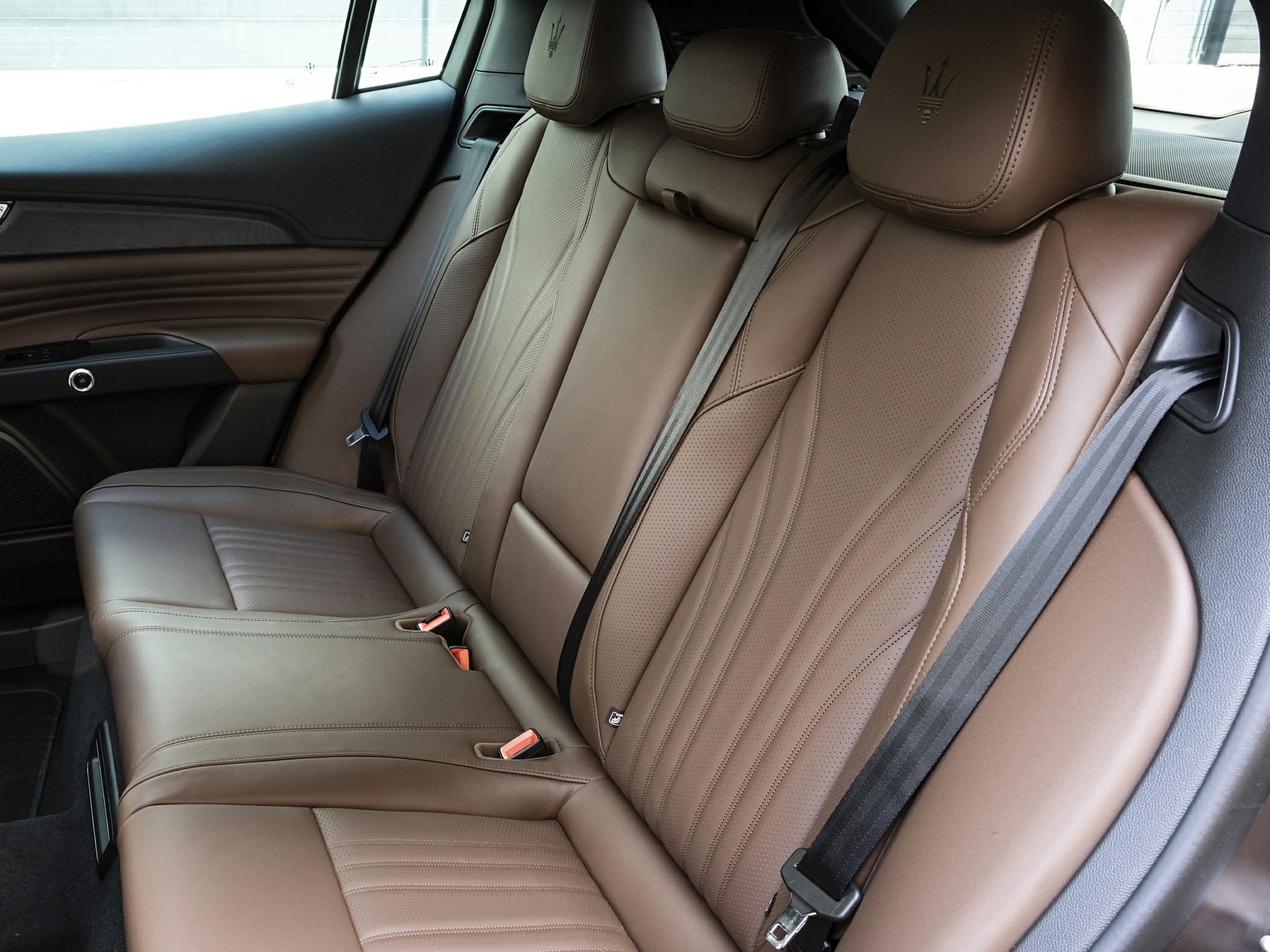 Brown leather rear seats with detailed stitching and headrests