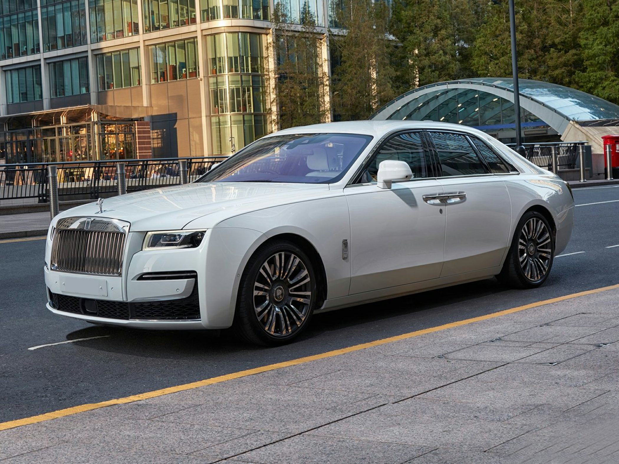 Luxury white sedan with prominent front grille and multi-spoke alloy wheels