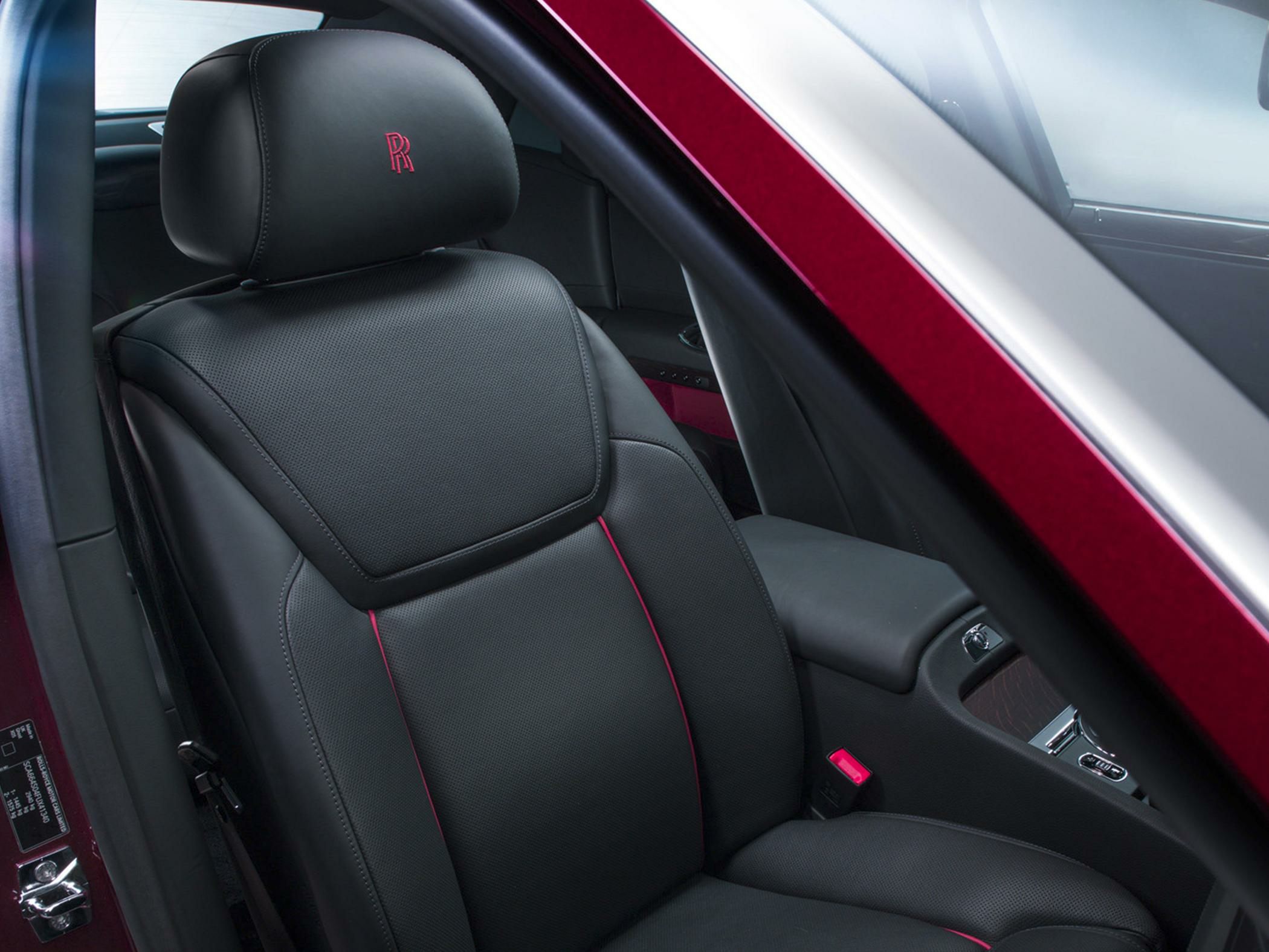 Black leather luxury front seat with embroidered headrest and red stitching details