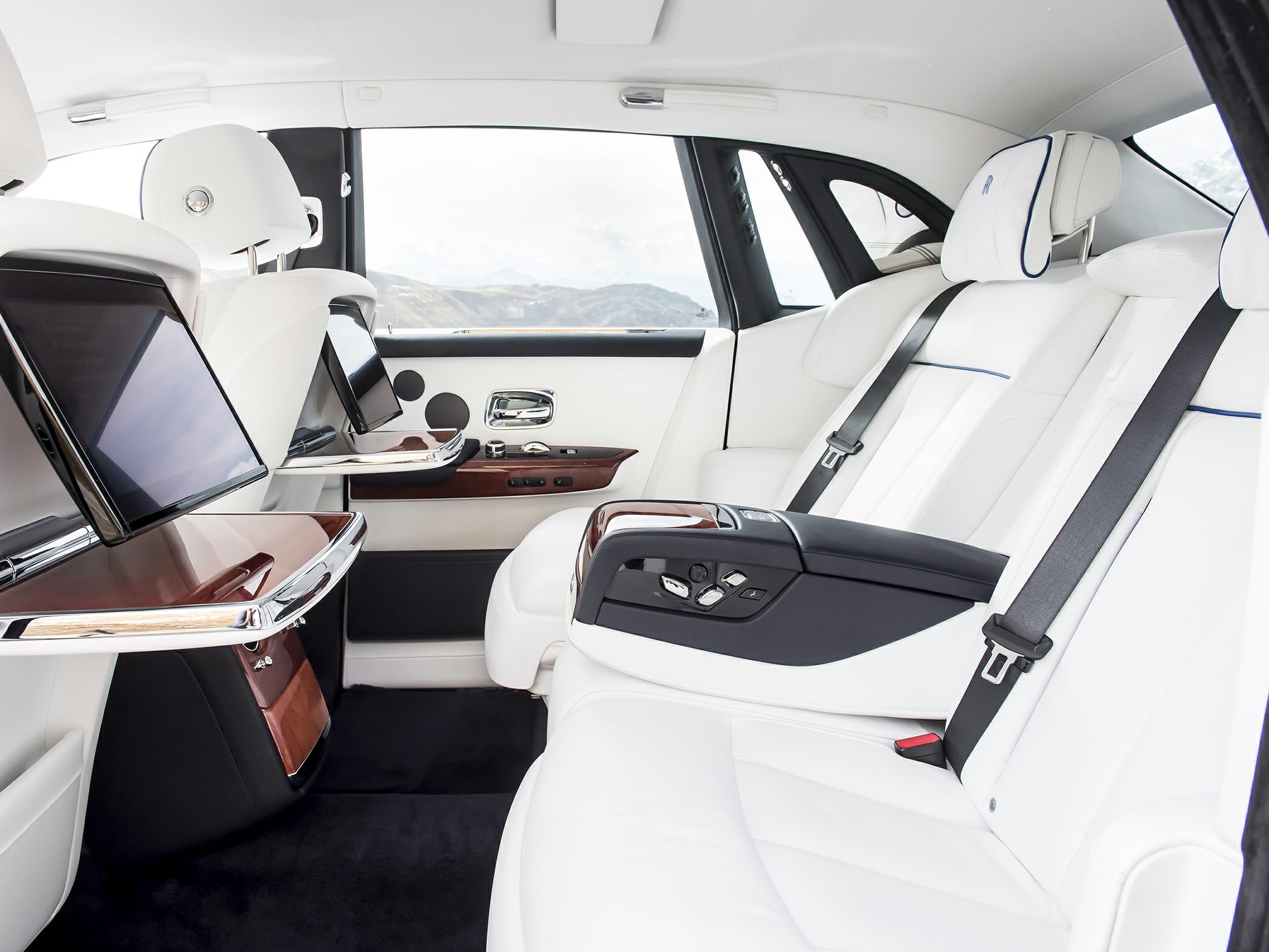 White leather rear seats with entertainment screens and wood trim