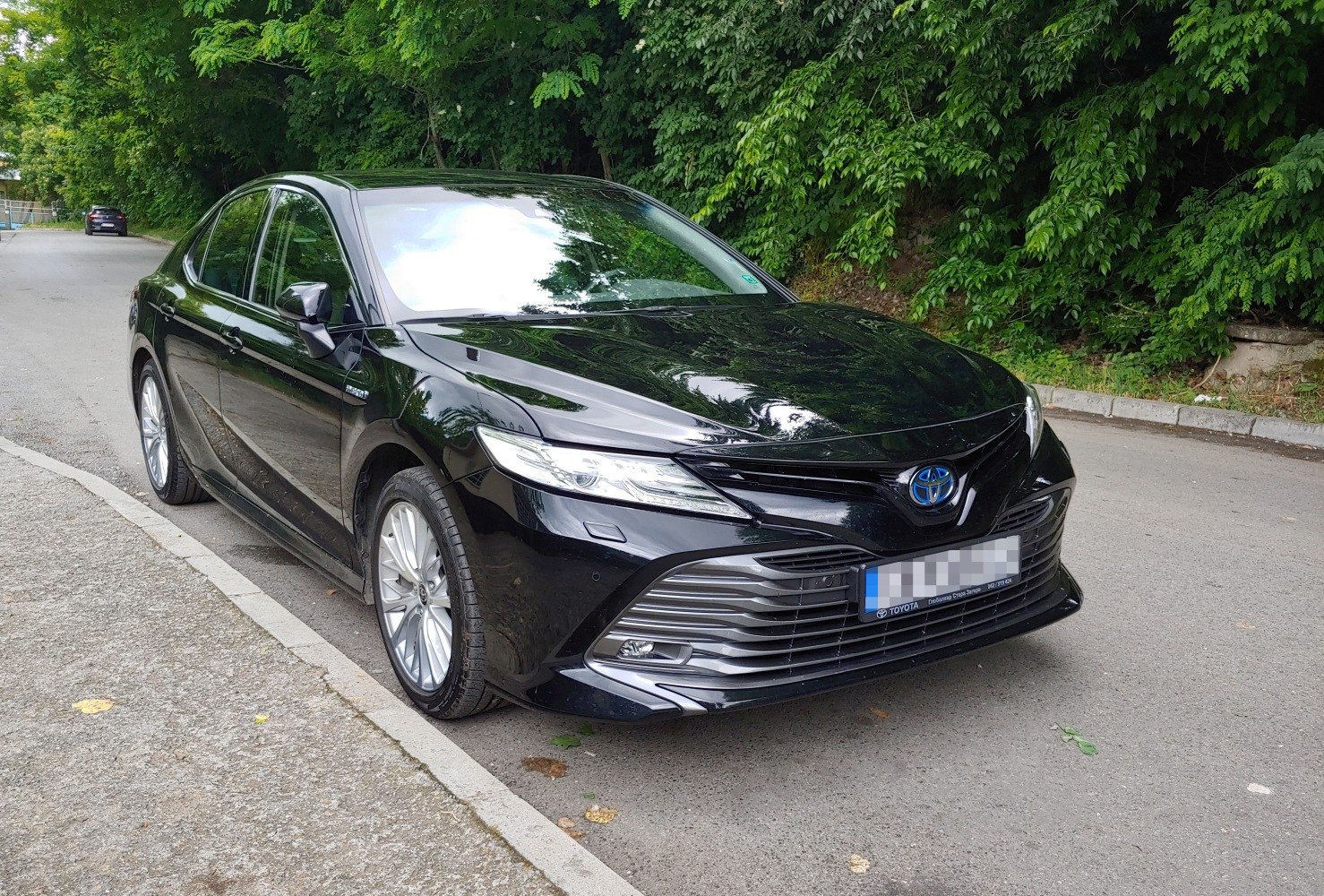 Black sedan with distinctive LED headlights and prominent front grille