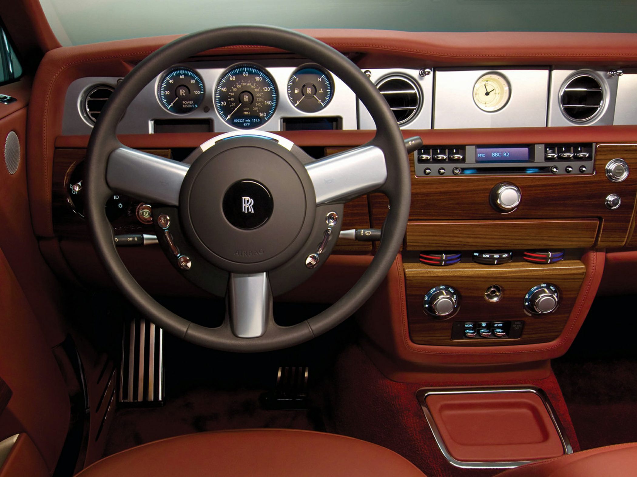Luxury interior with wood trim, analog gauges, and classic steering wheel design