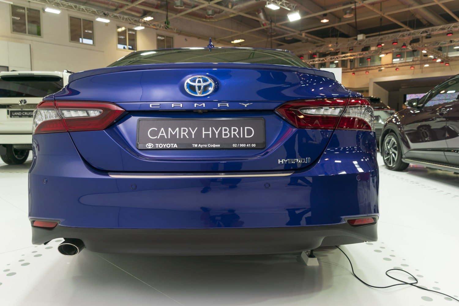 Rear view of hybrid sedan with taillights and hybrid badge