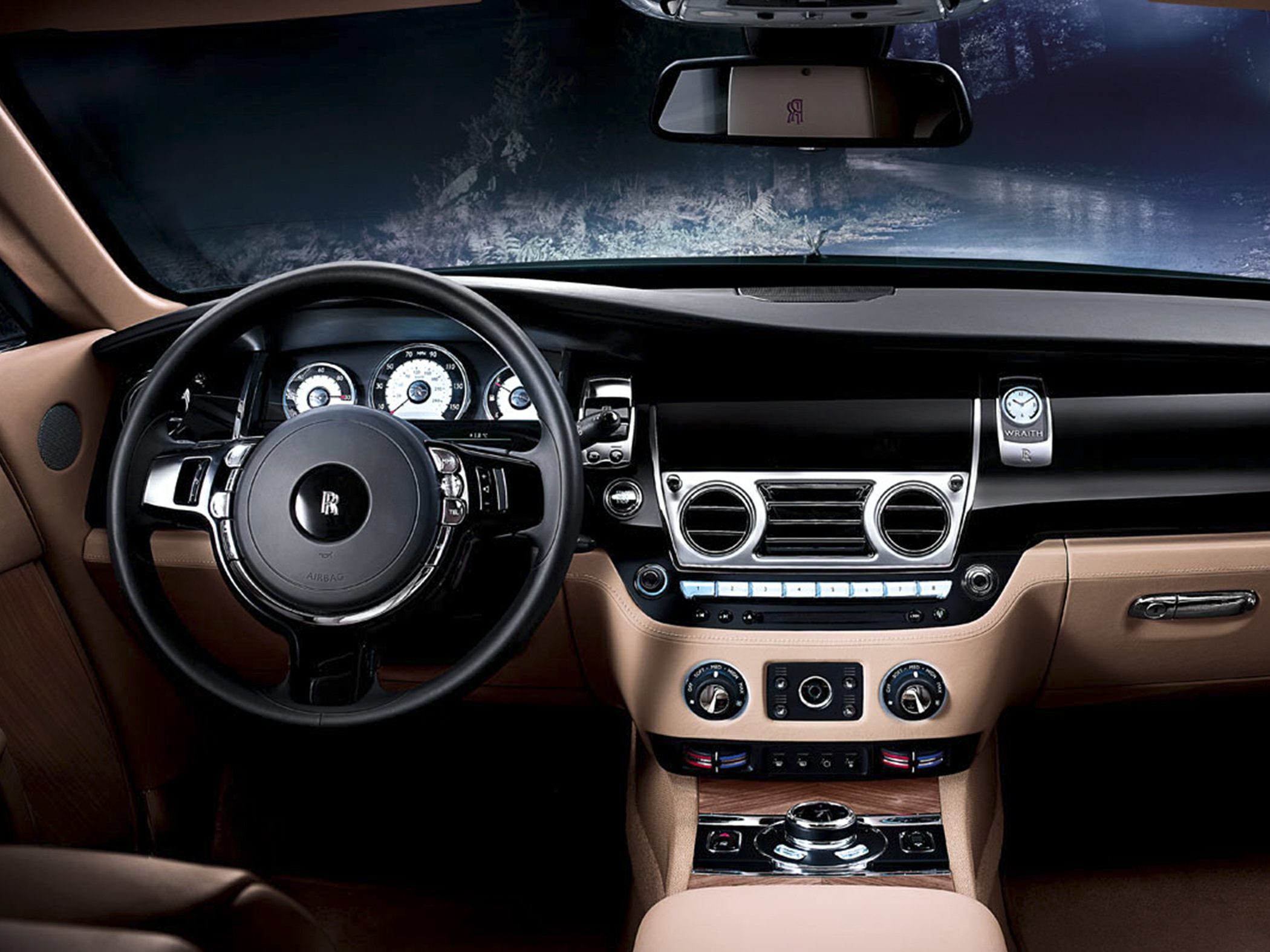 Luxury steering wheel and dashboard with climate controls and analog gauges.