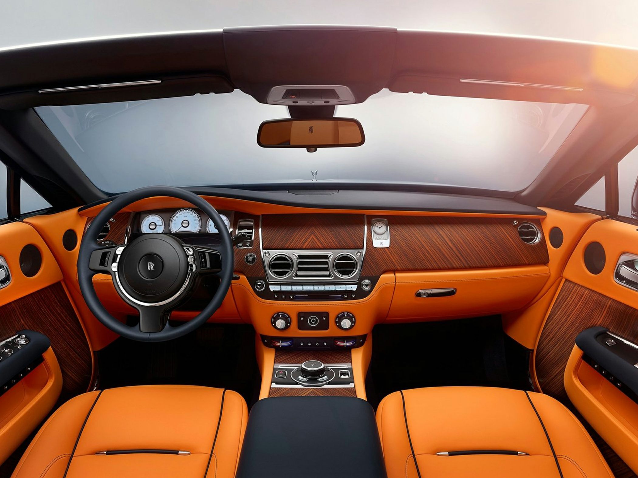 Luxury orange leather seats with wood-trimmed dashboard and steering wheel