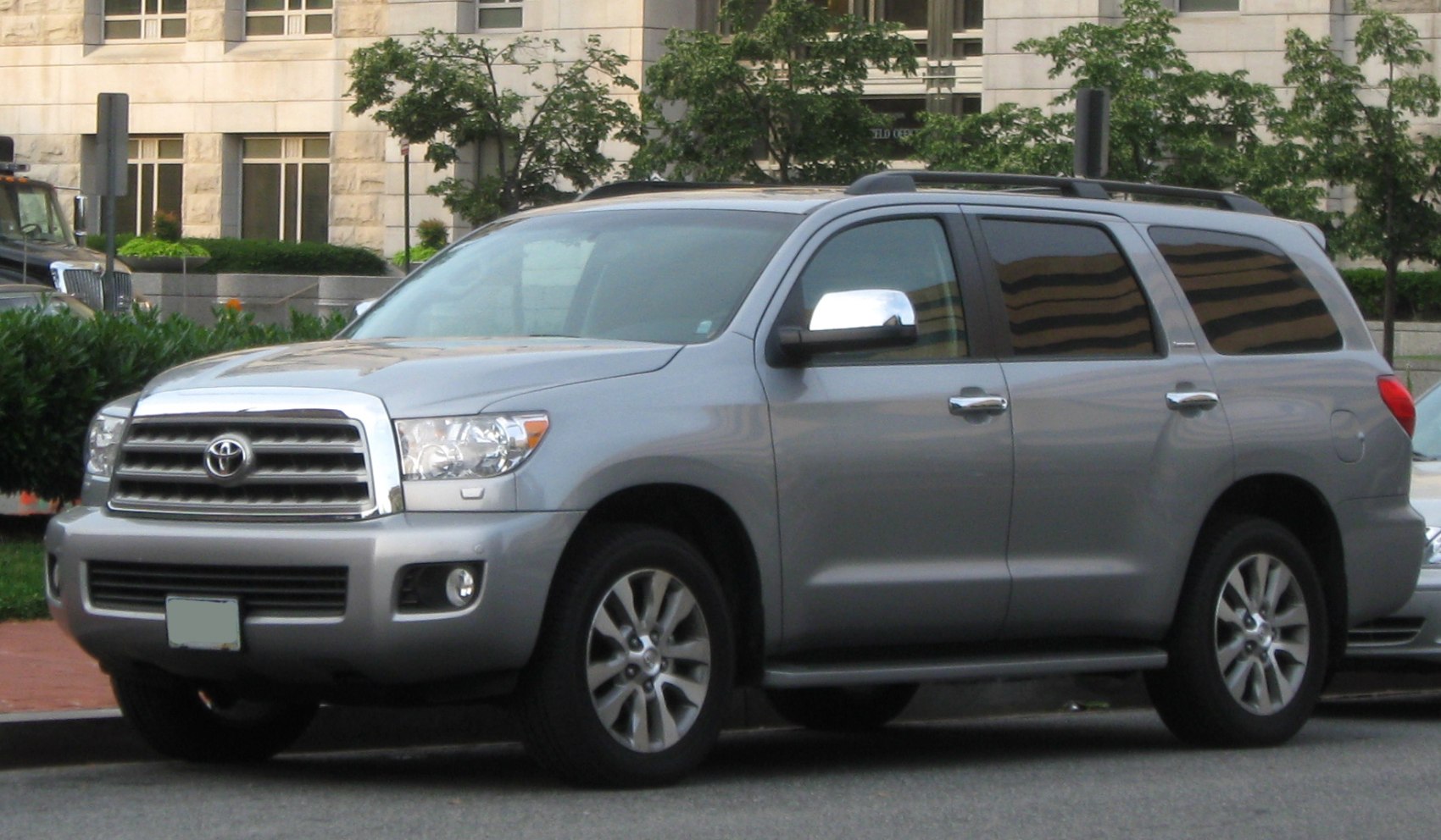 Silver SUV with chrome grille and roof rails, side and front view.