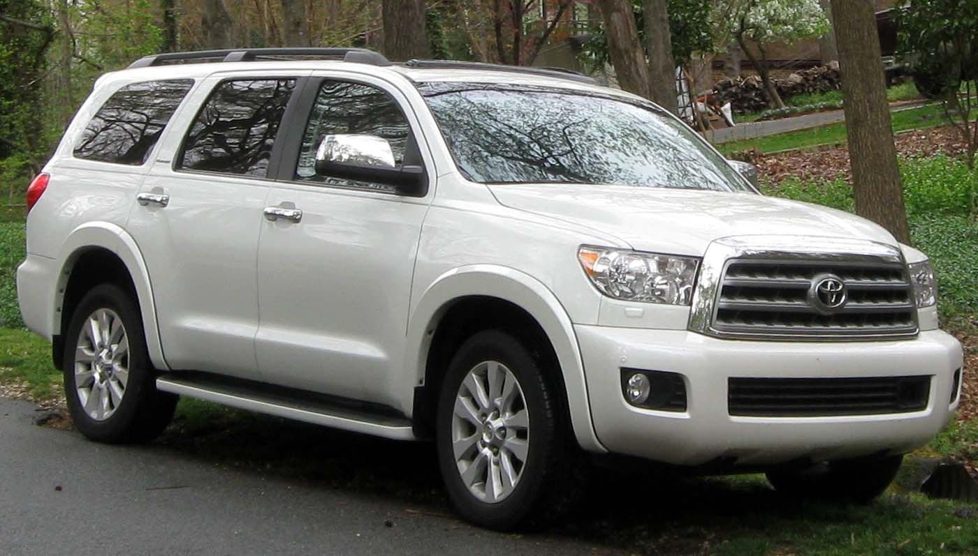 White full-size SUV with chrome grille, running boards, and roof rails.