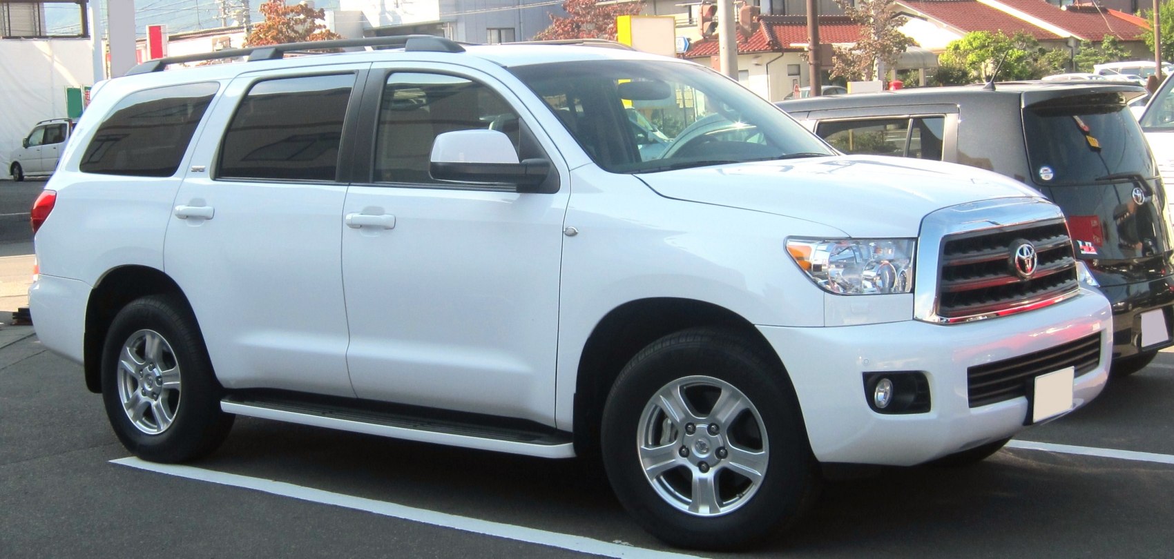 White large SUV front and side view with roof rack and alloy wheels