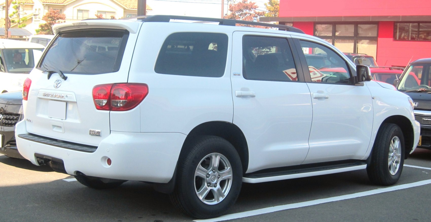 White large SUV rear side with tail lights, alloy wheels, tinted windows