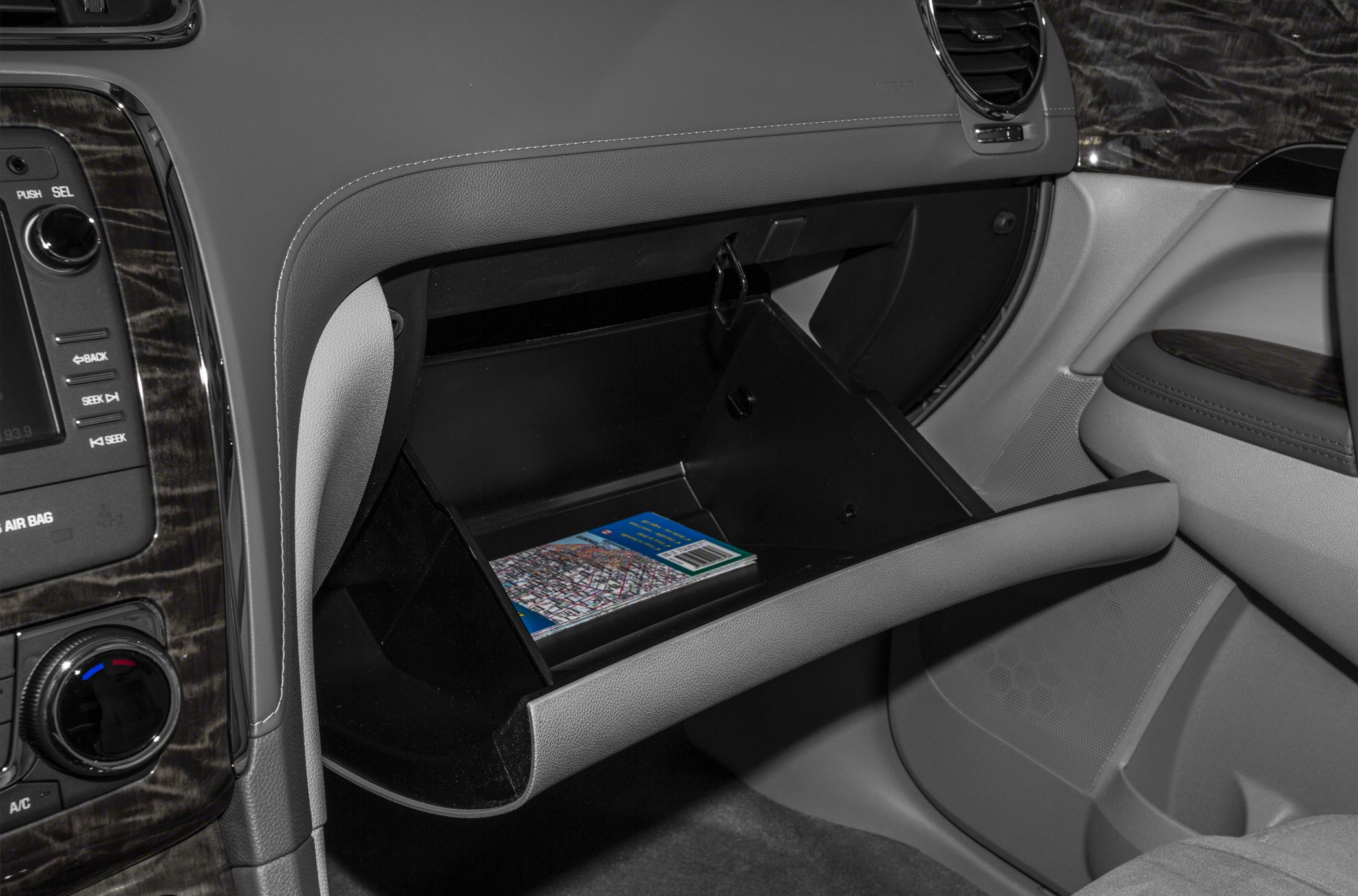 Open interior glovebox with booklet in car dashboard area