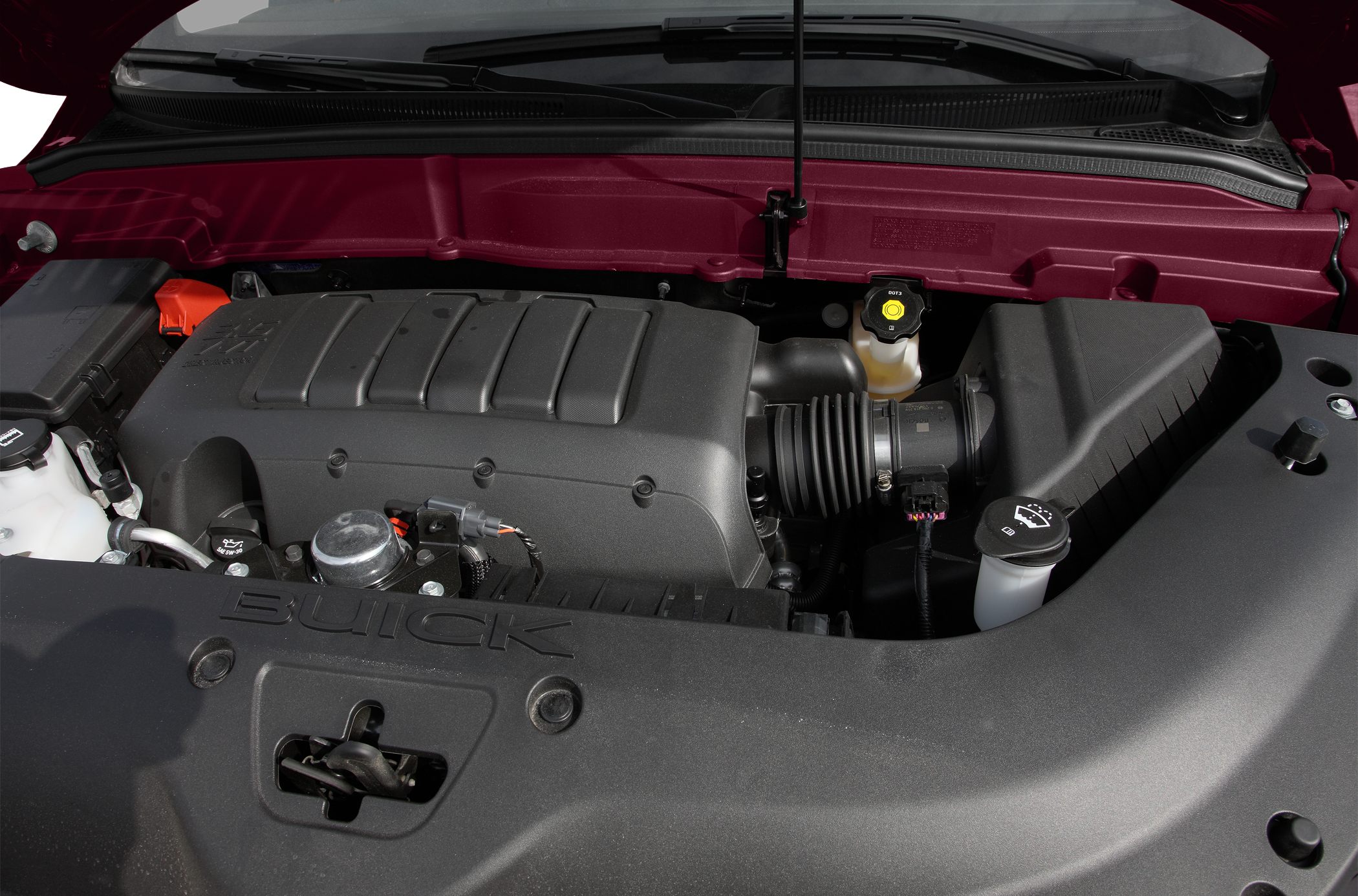 Engine bay with engine cover and fluid reservoirs.