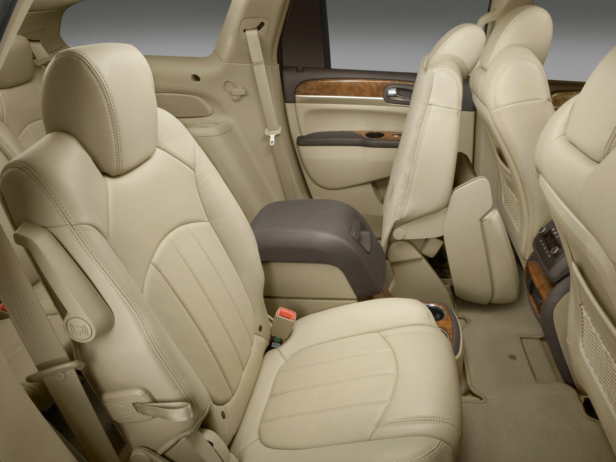 Beige leather rear seating with wood trim and armrest console