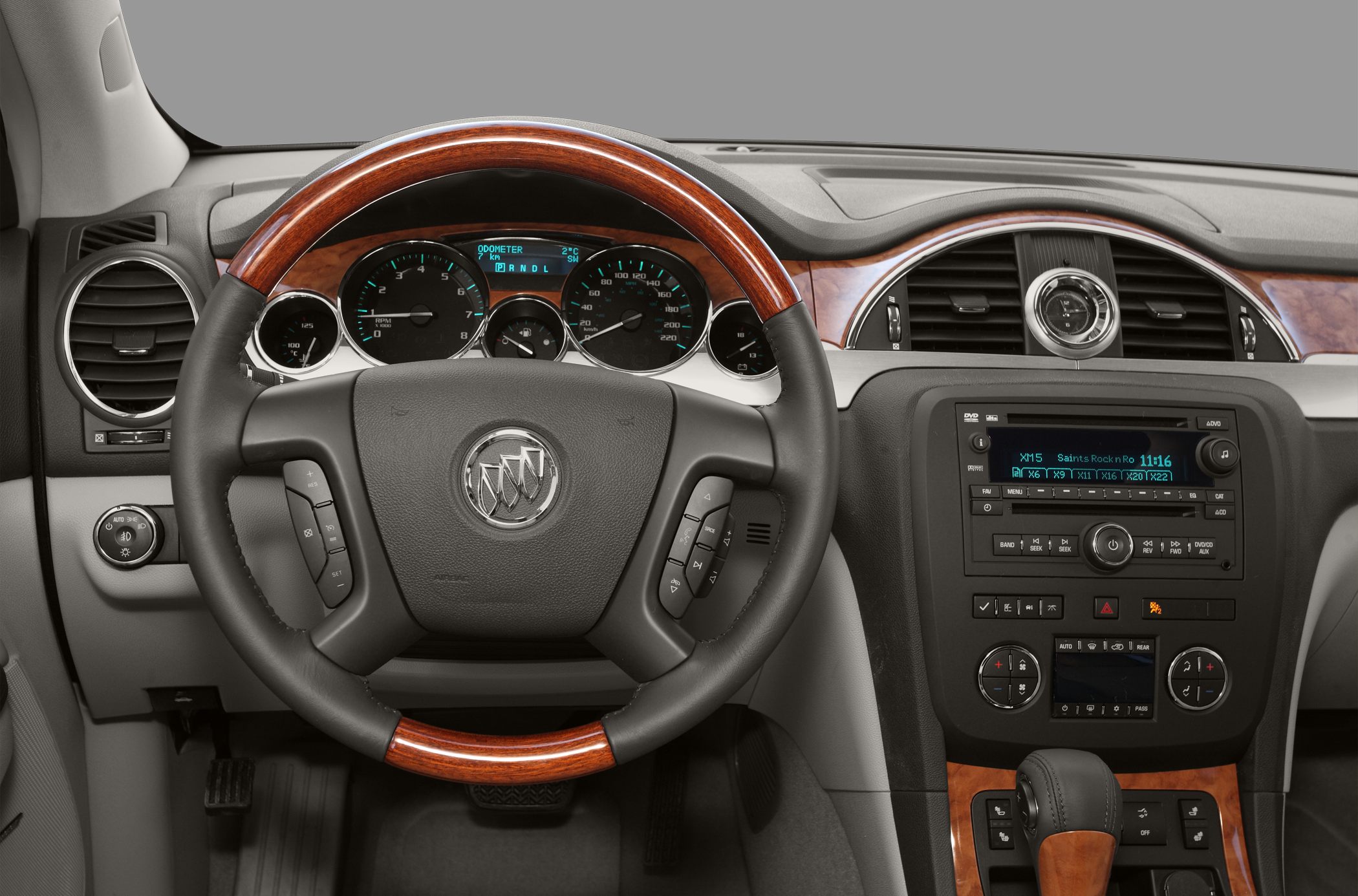 Steering wheel with wood trim and dashboard with instrument cluster and controls