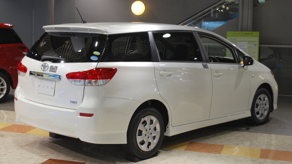 Rear side view showing tail lights, rear spoiler, alloy wheels, and window design