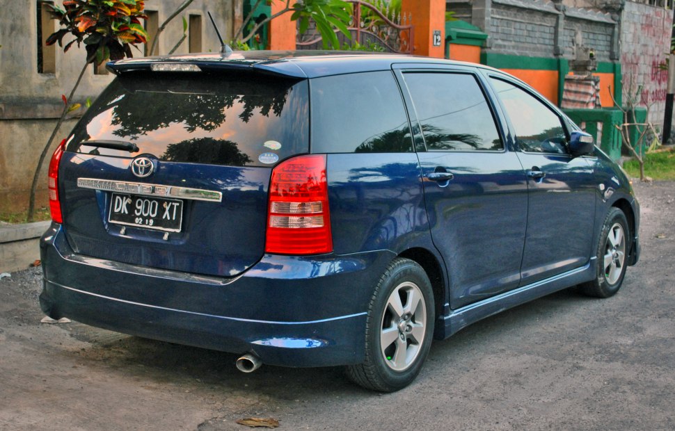 Rear and side view of blue minivan with spoiler and alloy wheels