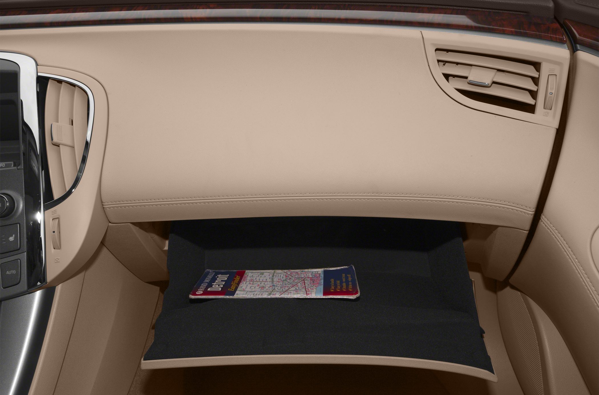 Beige car interior with open glove compartment and navigation map inside