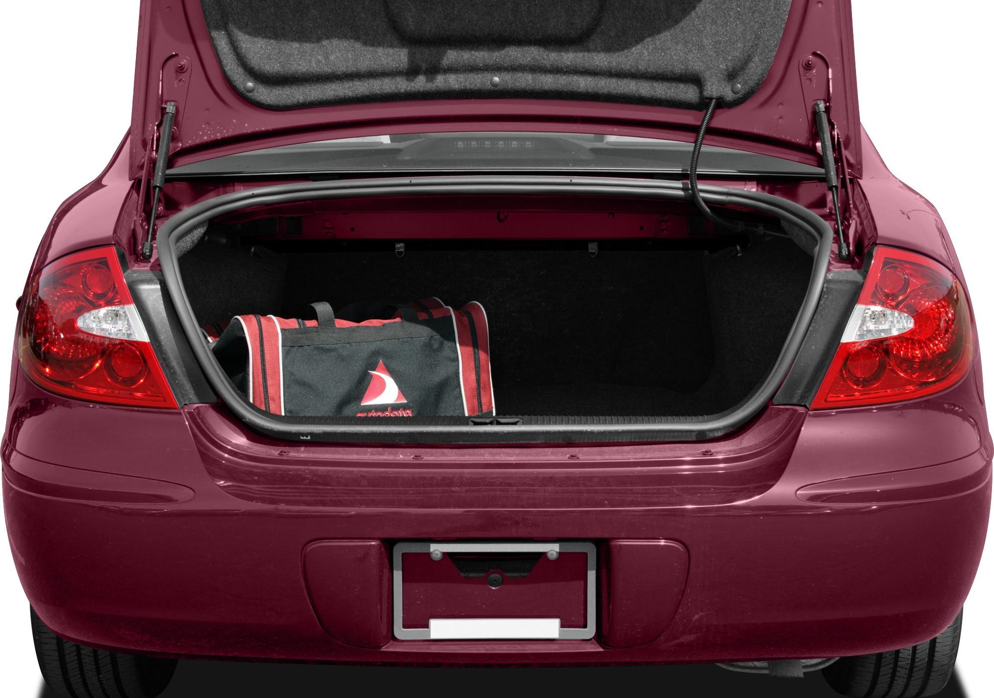 Open sedan trunk with red and black bag inside.