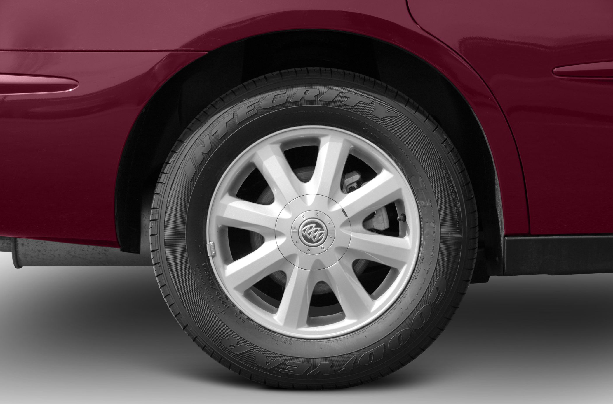 Alloy wheel with Goodyear Integrity tire on a maroon vehicle.