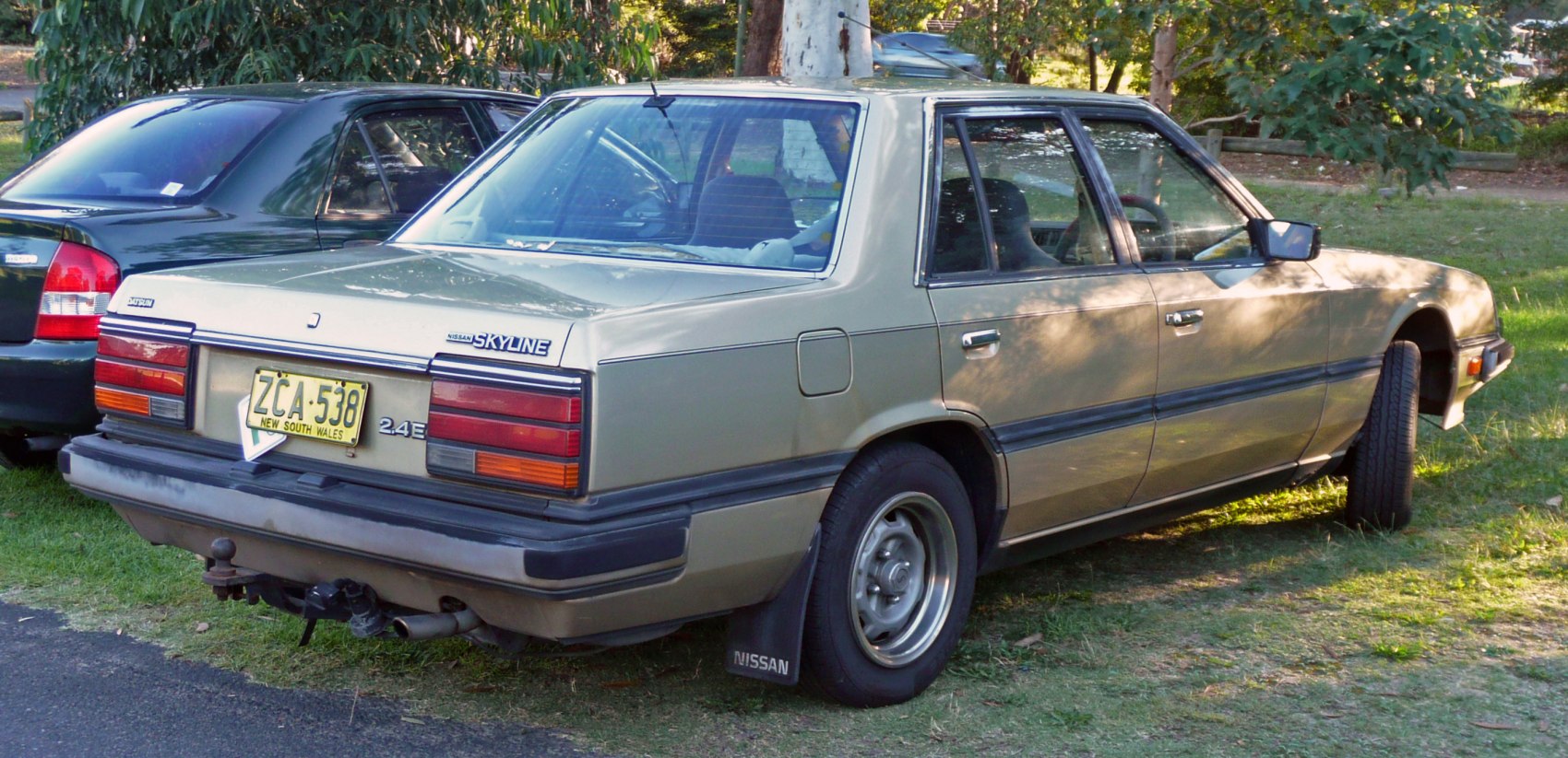 Rear view of 1980s sedan with square tail lights and tow hitch