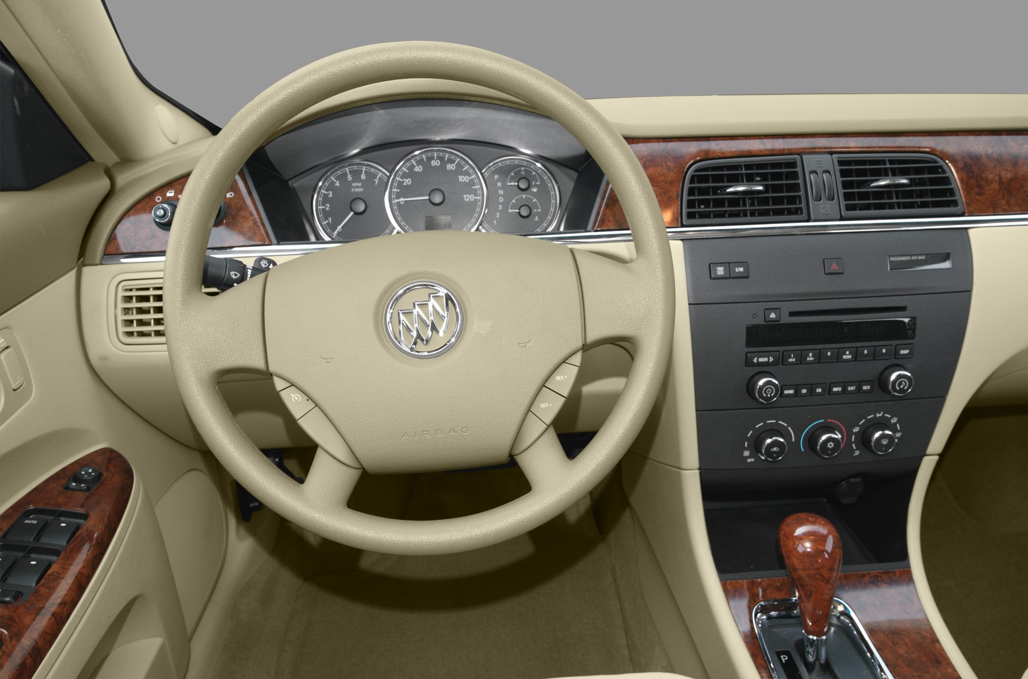 Beige steering wheel and dashboard with wood trim and instrument cluster