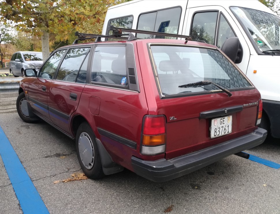 Red vintage station wagon with roof rack and rear windshield wiper