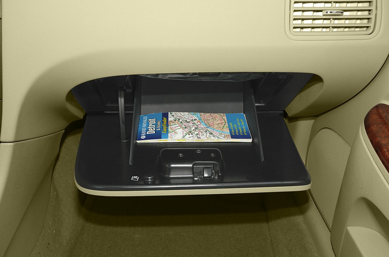 Open glove box with a map inside in beige car interior