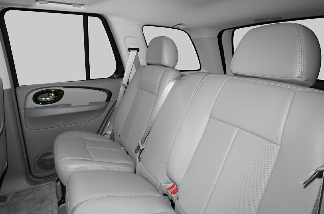 Leather rear seats with headrests and seatbelts inside an SUV.
