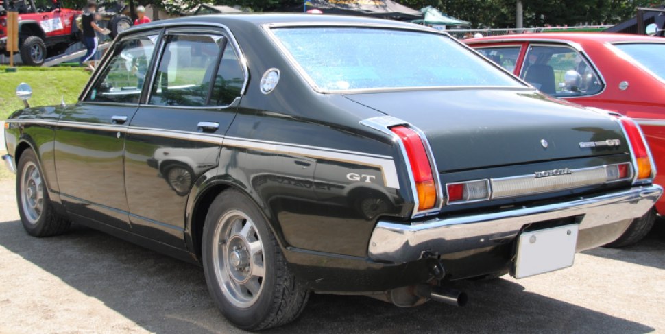 Rear view of vintage Toyota sedan with GT badge, chrome bumper, and classic taillights