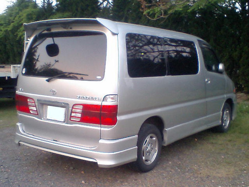Rear view of silver minivan with tinted windows and rear spoiler