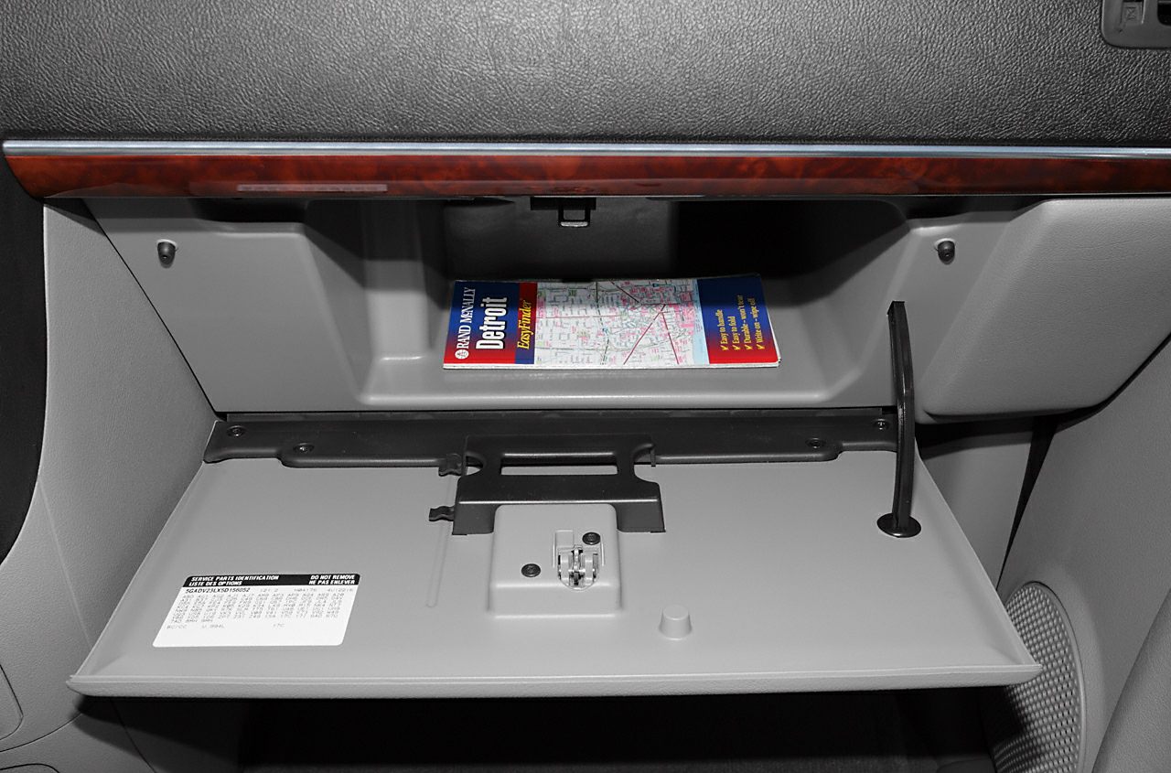 Open glove box with wood trim and Detroit map