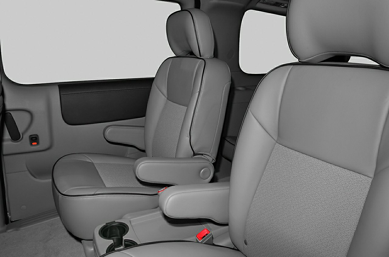 Spacious minivan interior with front and rear seats featuring armrests and leather upholstery.