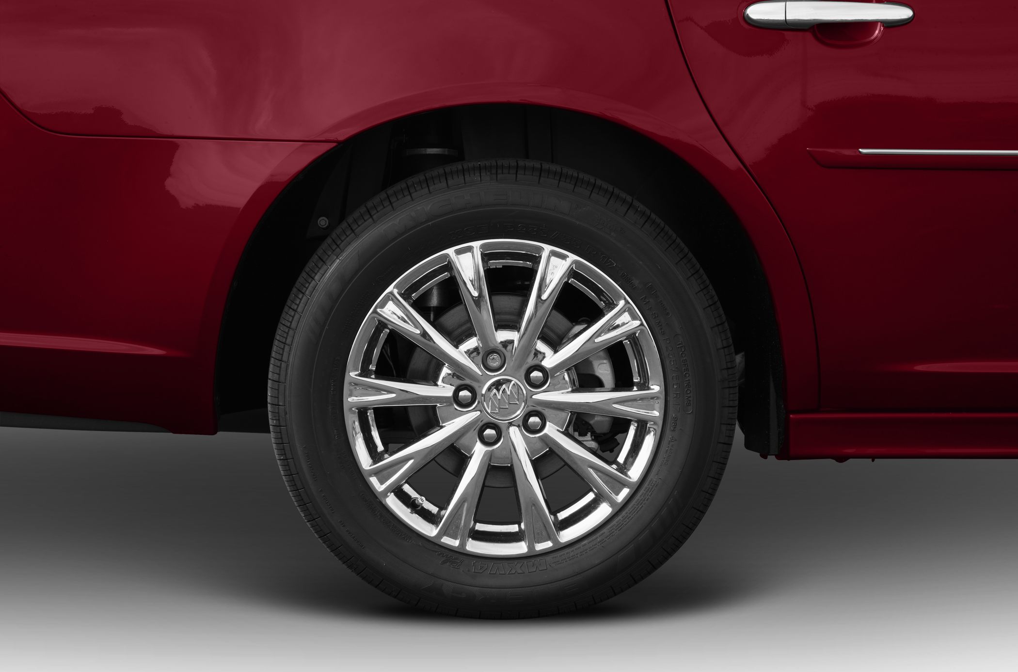 Chrome alloy wheel and door handle on red car panel
