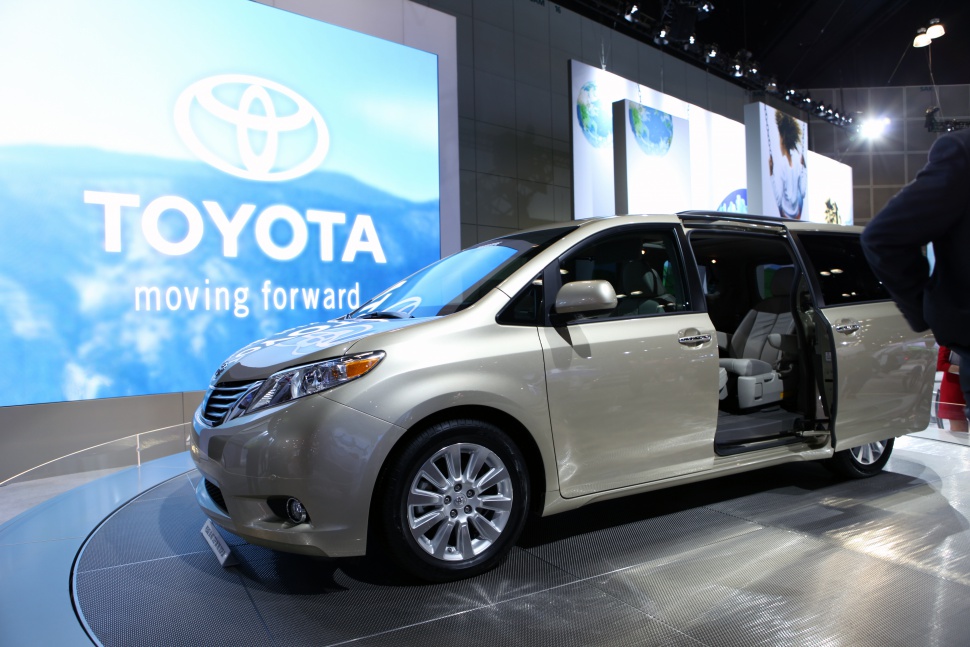 Minivan with open sliding door showing interior seating and alloy wheels