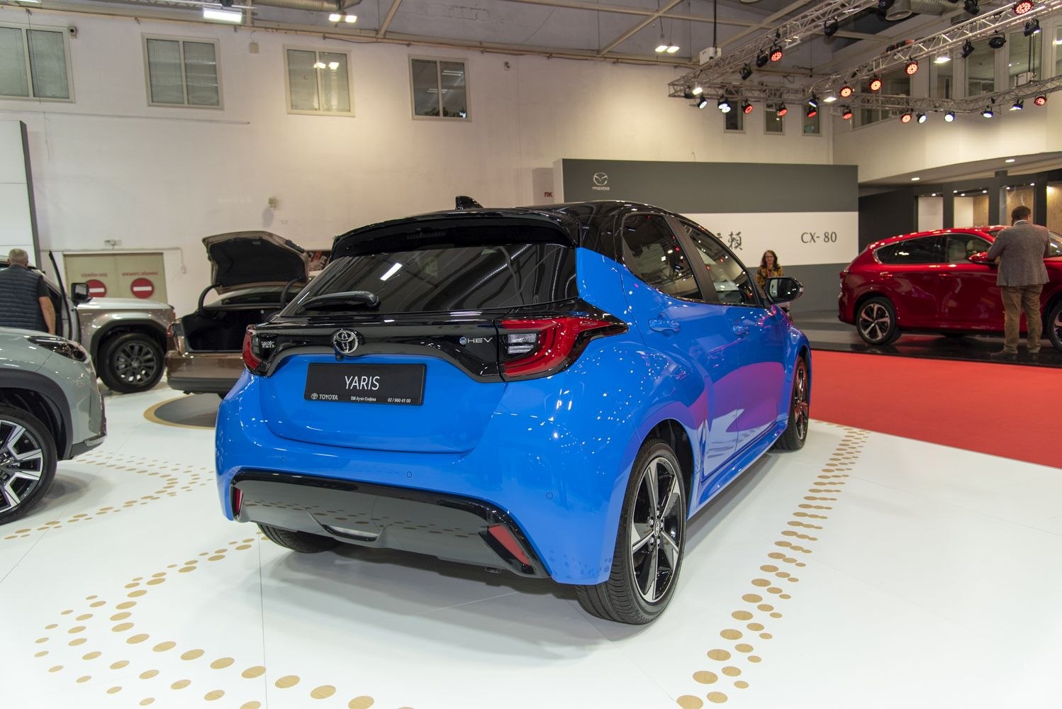 Rear three-quarter view of blue hatchback with black roof and distinct taillights
